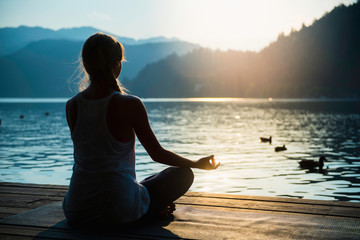 Man praying at sunset mountains with raised hands