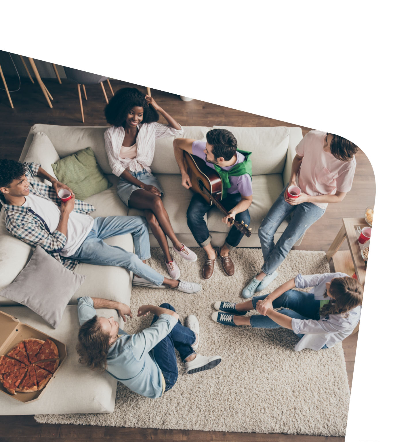 Group of young people sitting in living room and having fun together