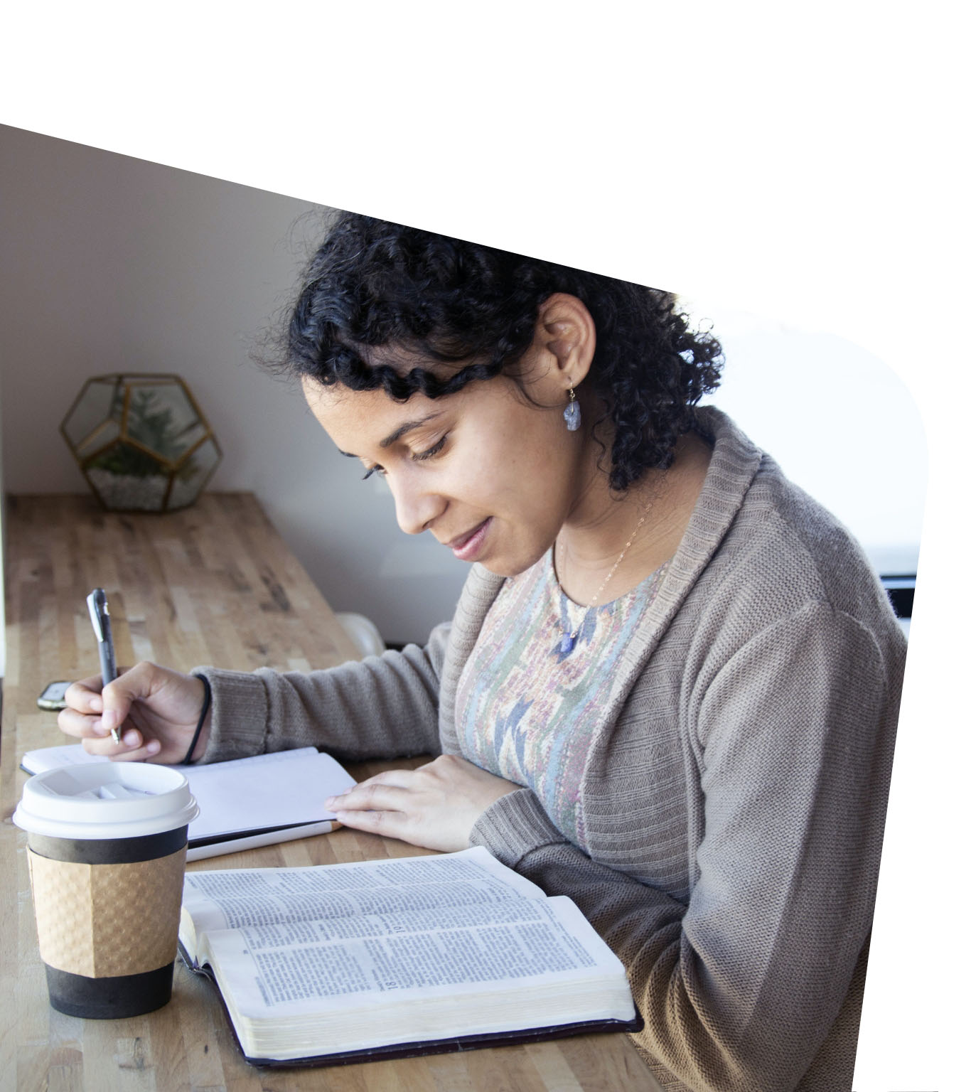 Woman taking notes while reading a Bible