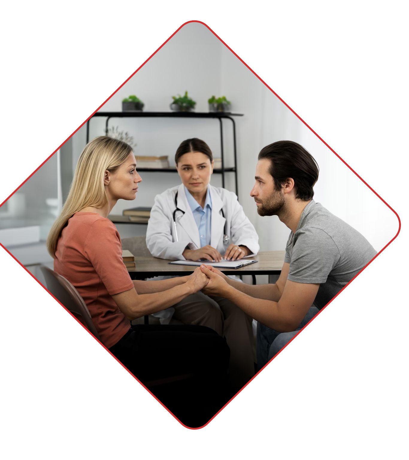 Doctor listening to a married couple as they hold hands during a patient visit