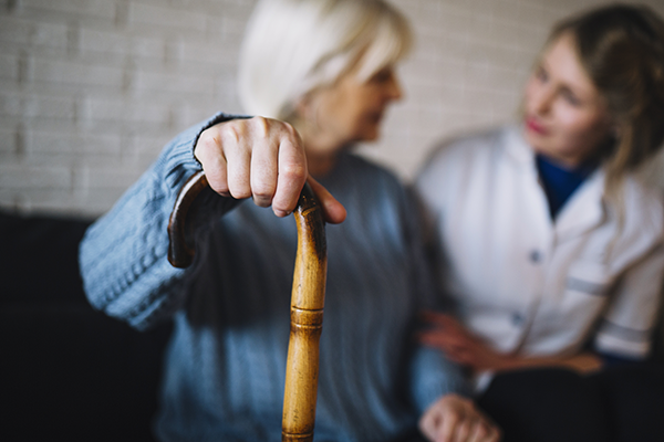 health care provider and elderly woman with cane